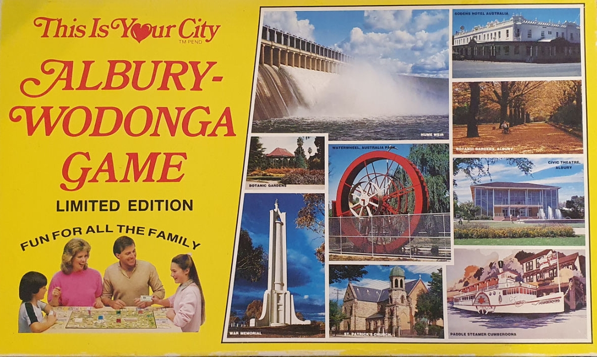 THIS IS YOUR CITY ALBURY-WODONGA game box limited-edition fun for all the family. Features pictures of Old Hume Weir wall, War Memorial monument, Water Wheel among others. A family gathers around a table playing the board game.